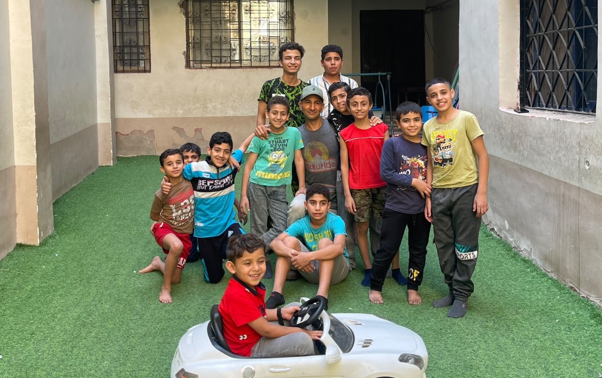 Dr. Michael Ghaly with the children of Rifka's House in the courtyard.